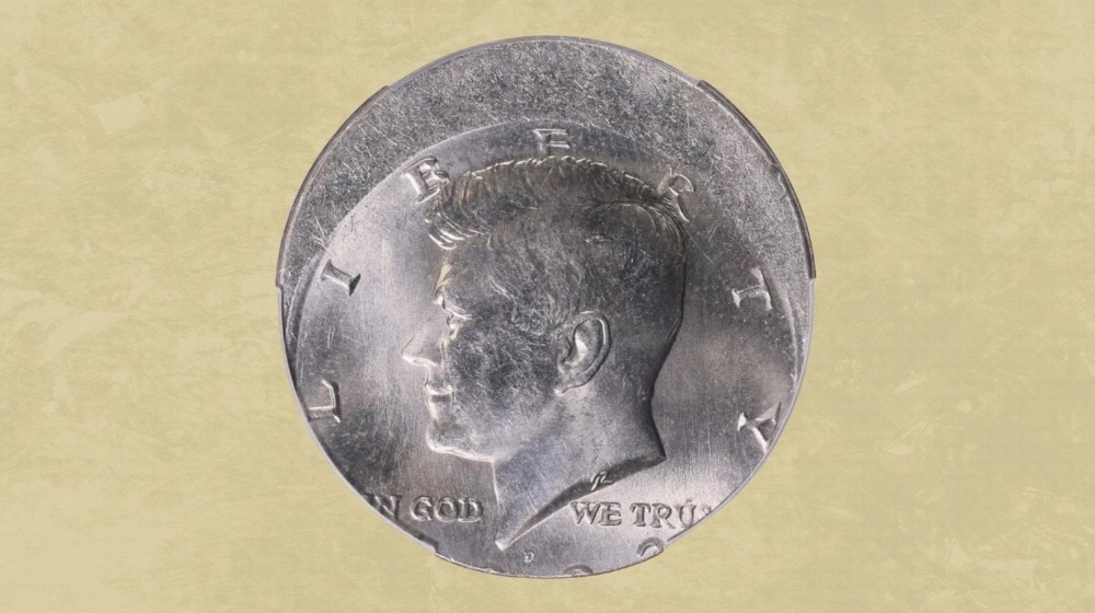 2025 Kennedy Half Dollar off-center strike error showing design shifted off-center with visible blank planchet area